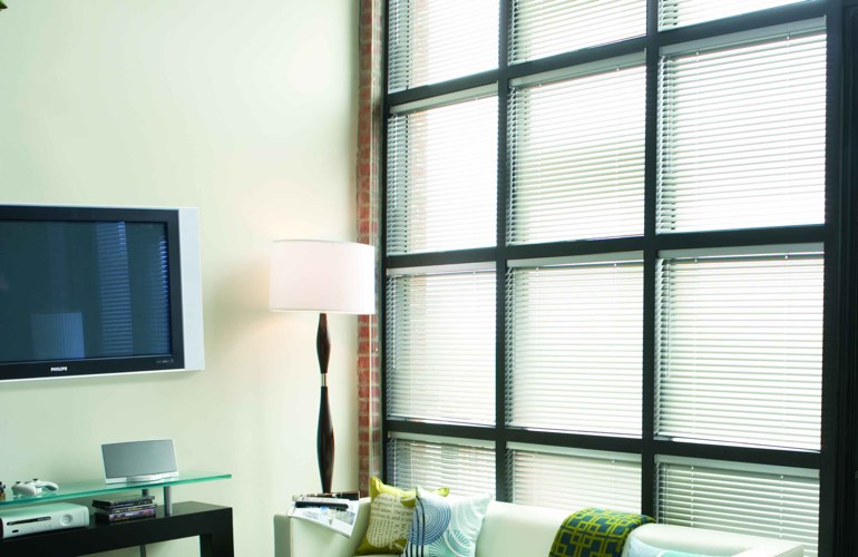 Blinds covering large window that’s divided into square panes